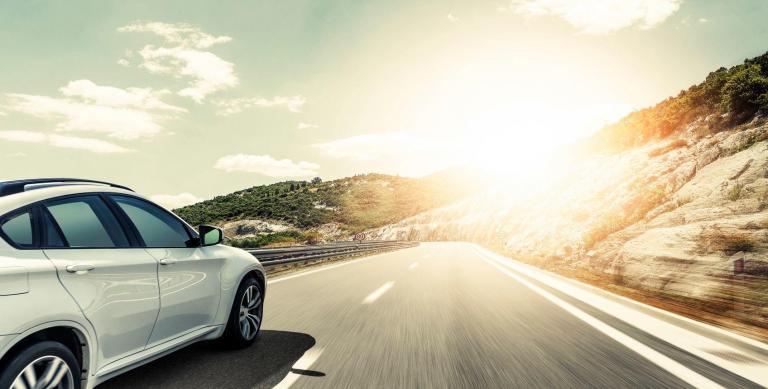car on the road towards sunrise